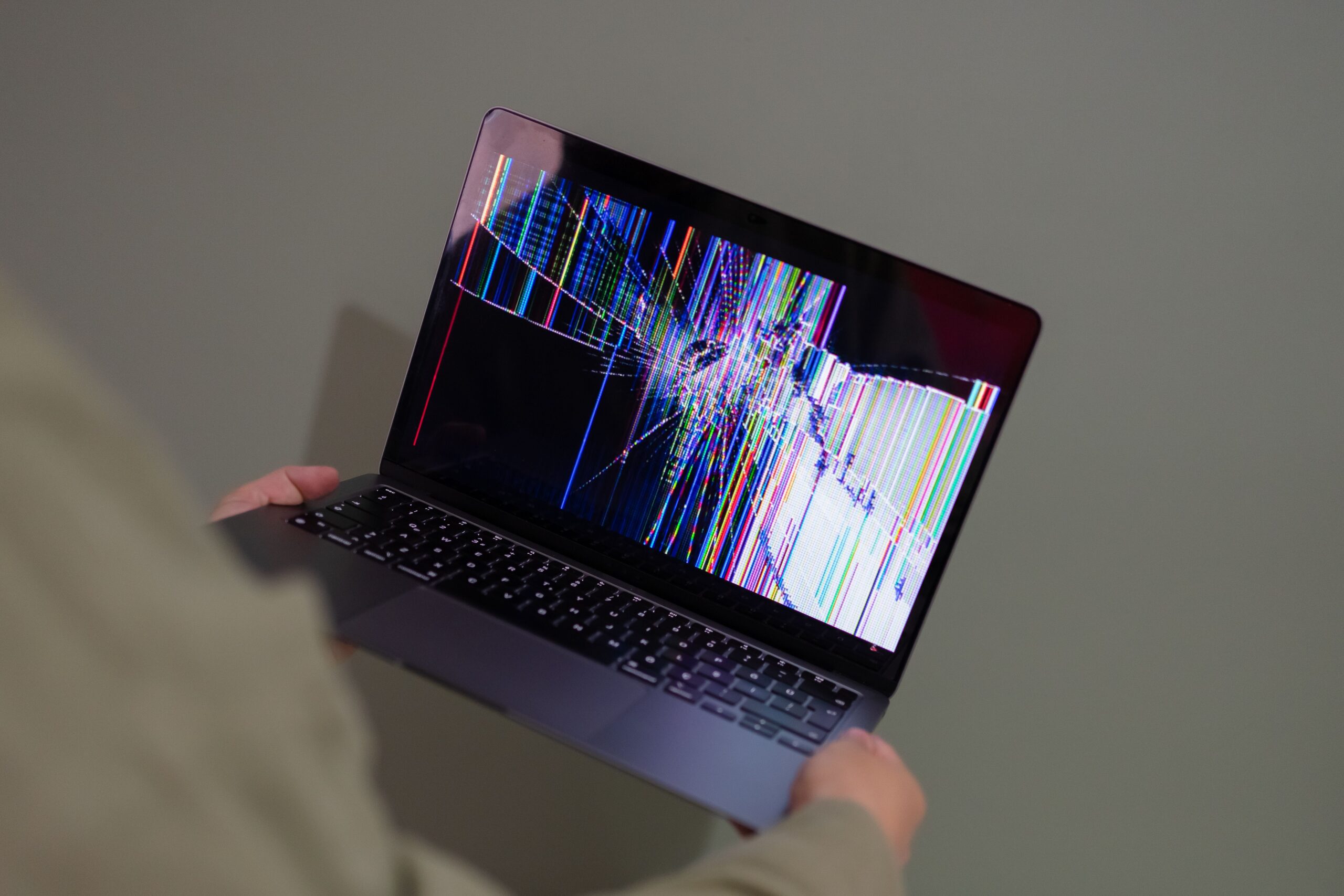 Broken laptop screen with colorful glitch representing a failing website
