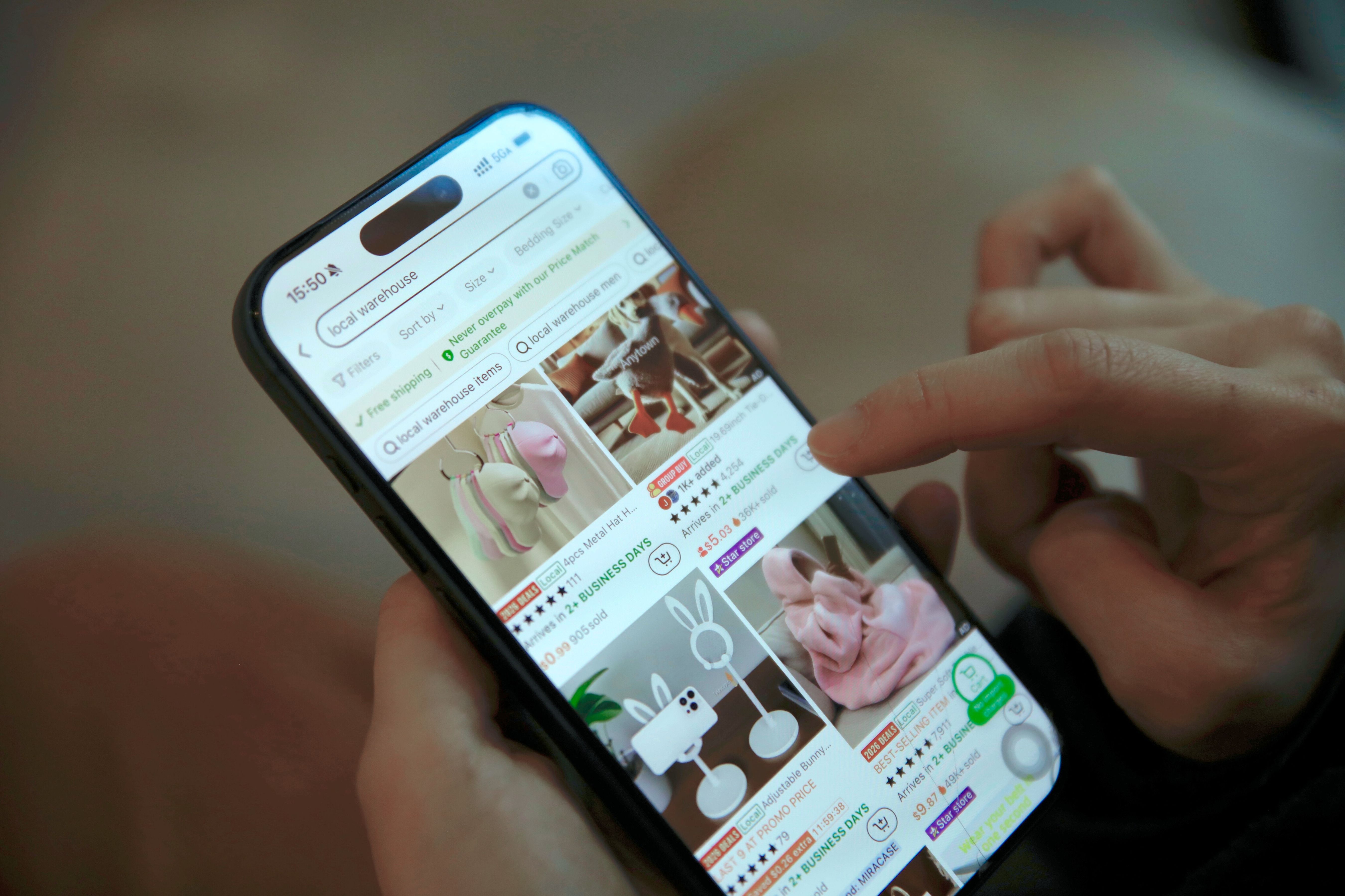 Person browsing a shopping app on a smartphone, representing Amazon-style ecommerce advertising.