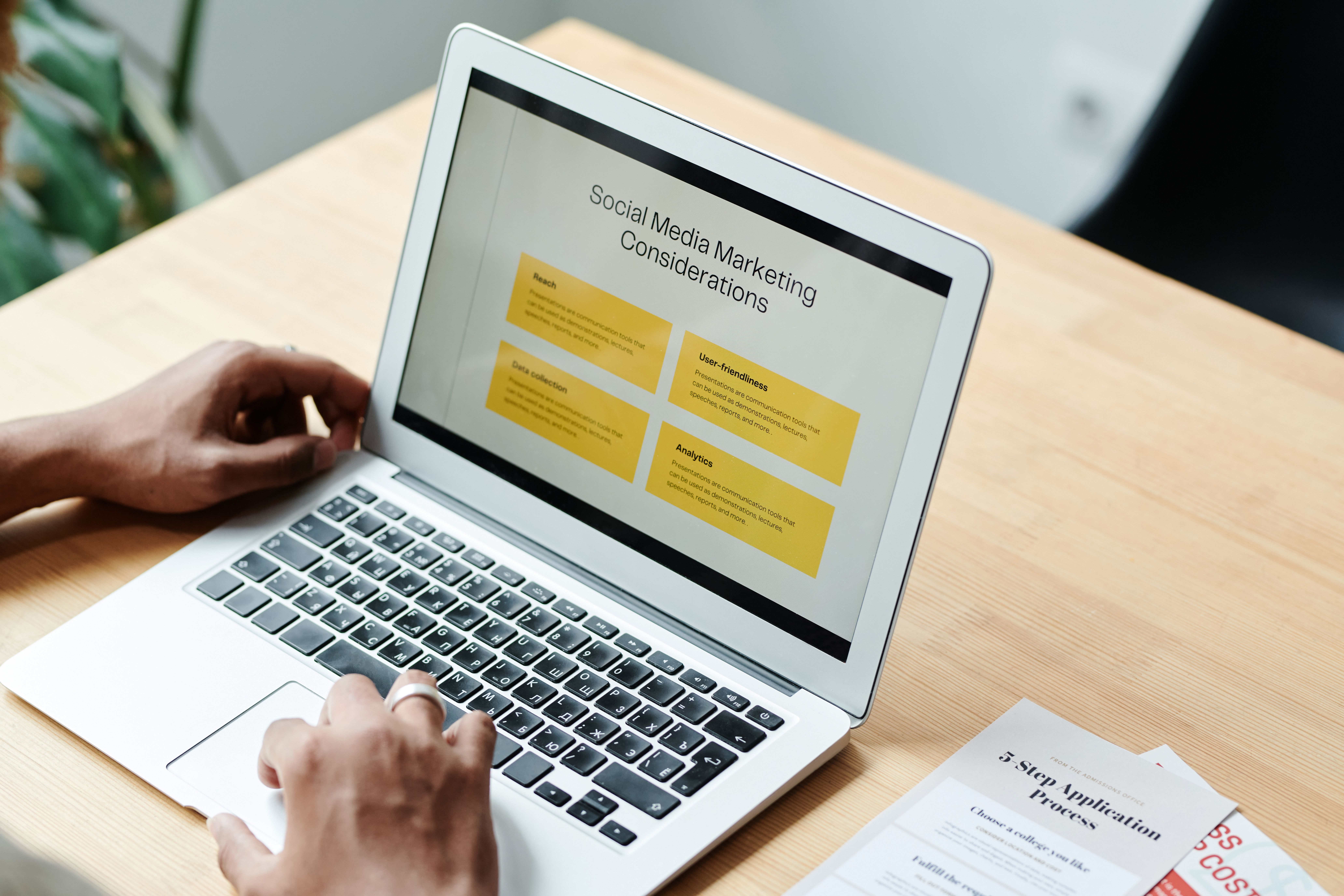Person using a laptop to review social media marketing strategy and campaign planning.