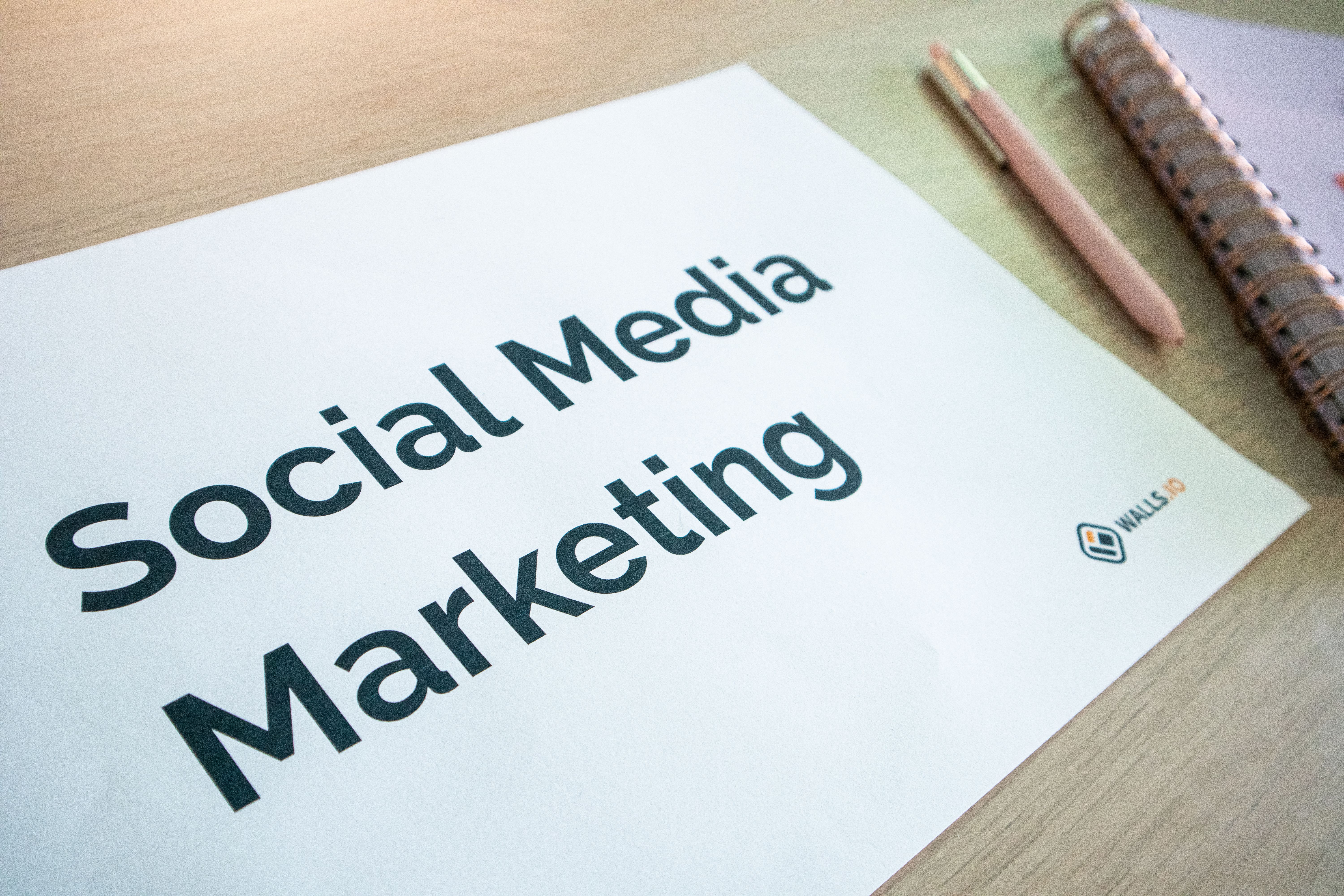 Social media marketing notes on a desk, illustrating ad planning and platform-specific publishing.